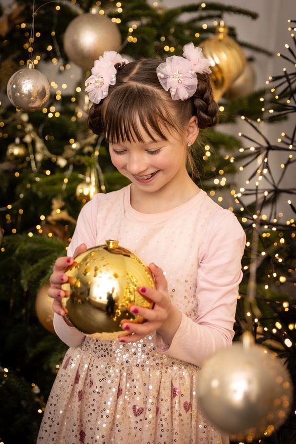 Mädchen schaut verträumt auf ihre goldene Kugel