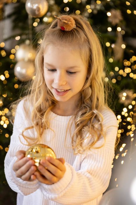 Mädchen mit Lichterkette und goldener Kugel