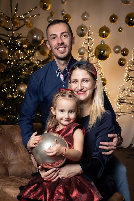 Familie mit Tochter vor dem Weihnachtsbaum