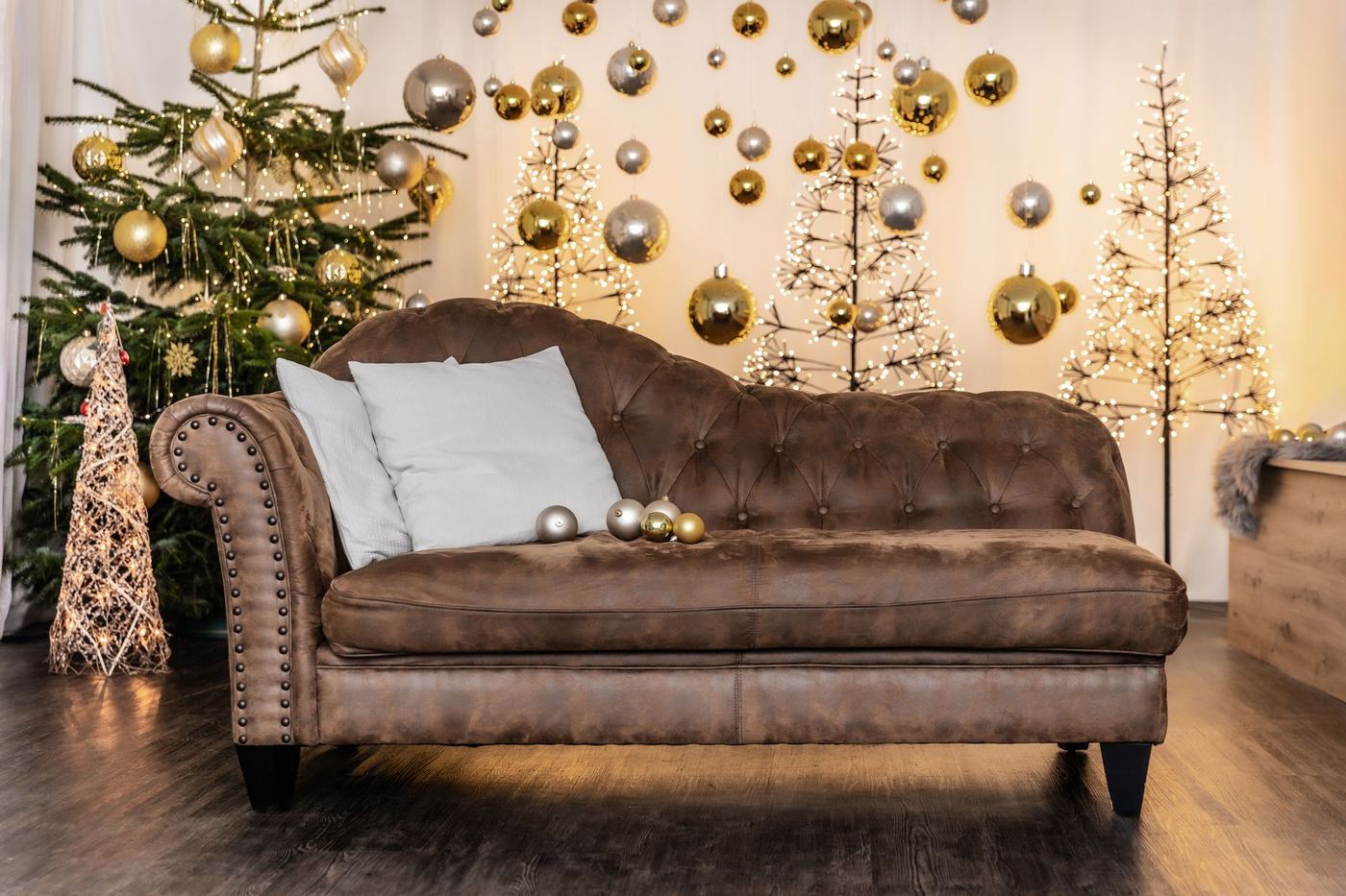Das Weihnachtsset im Studio: Chesterfield-Sofa, Christbaum, Lichterbäume und goldene Kugeln